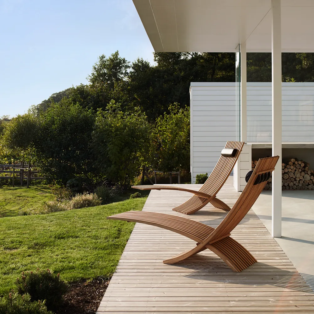 Nozib lounge chair, Teak, black neck rest in leather Skargaarden