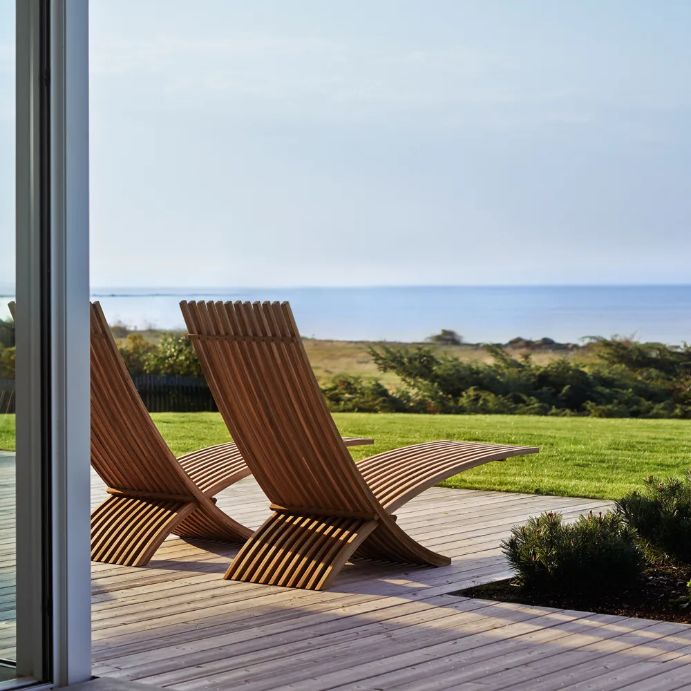 Nozib lounge chair, Teak, black neck rest in leather Skargaarden