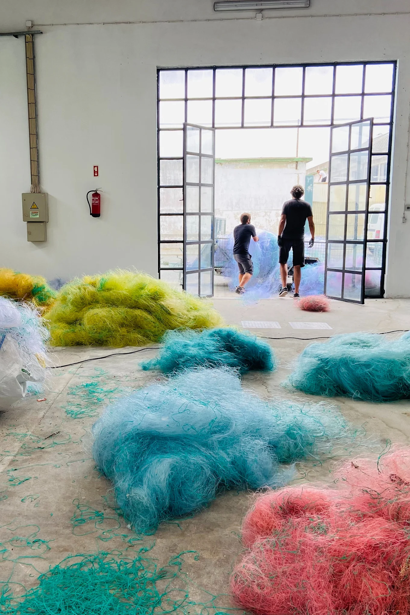 Here you see fishing nets that have been sorted by colour before they are ground down and turned into 3D printed furniture.