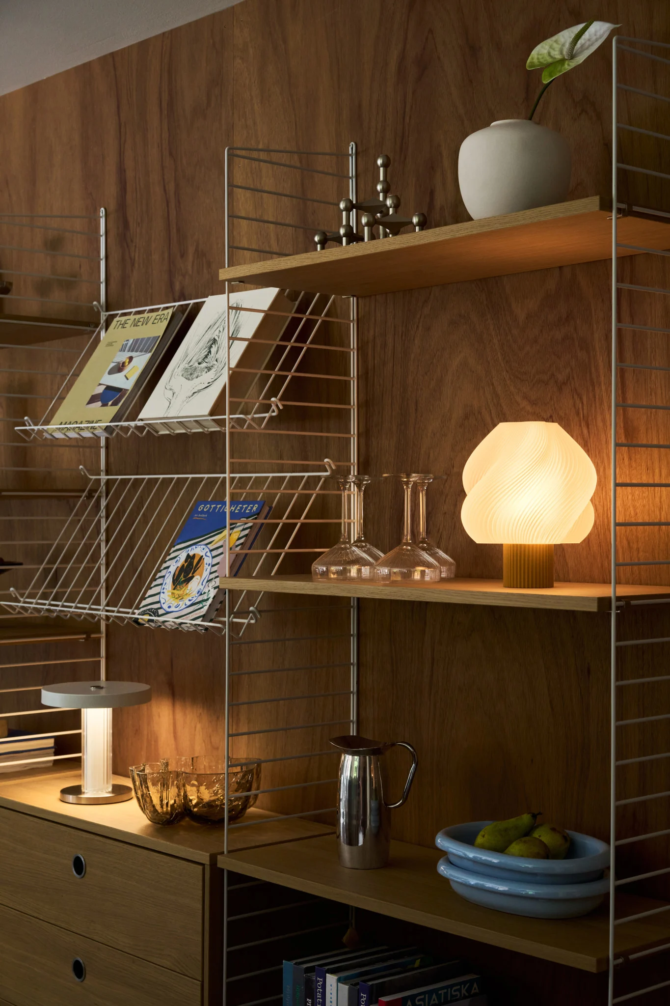Think about including multiple light sources when it comes to planning your lighting. Here you see a dining table with lots of different table lamps and a dramatic ceiling lamp. 