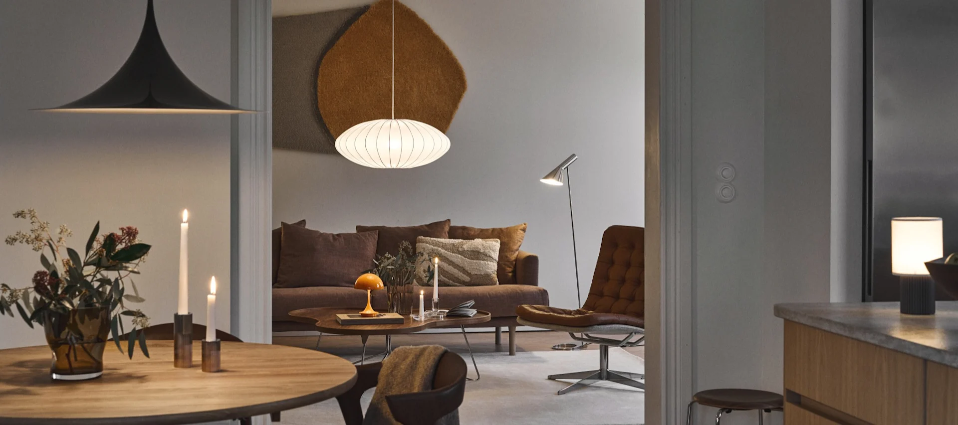Choosing the right light bulb is important for the feeling in your home - a man sitting on a sofa surrounded by different light sources, reading a book. 